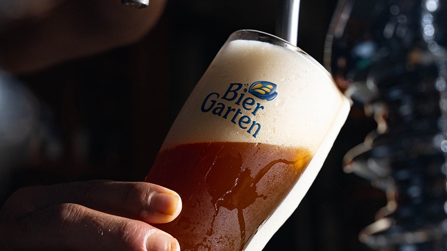 Bartender pouring a chilled glass of fresh craft beer on tap at Biergarten Bangalore.